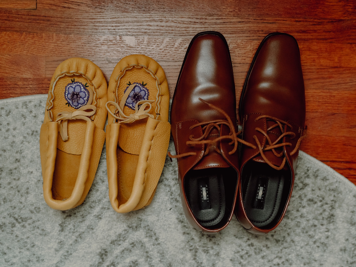 Couple getting ready for their elopement together at their home in Minneapolis, Minnesota. Bride and Groom’s shoes on the floor. Bride wearing moccasins.