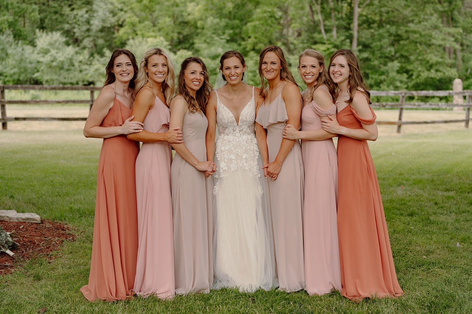 Rust, mismatched bridesmaids dresses. Wedding photos at Mayowood Stone Barn in Rochester Minnesota. 