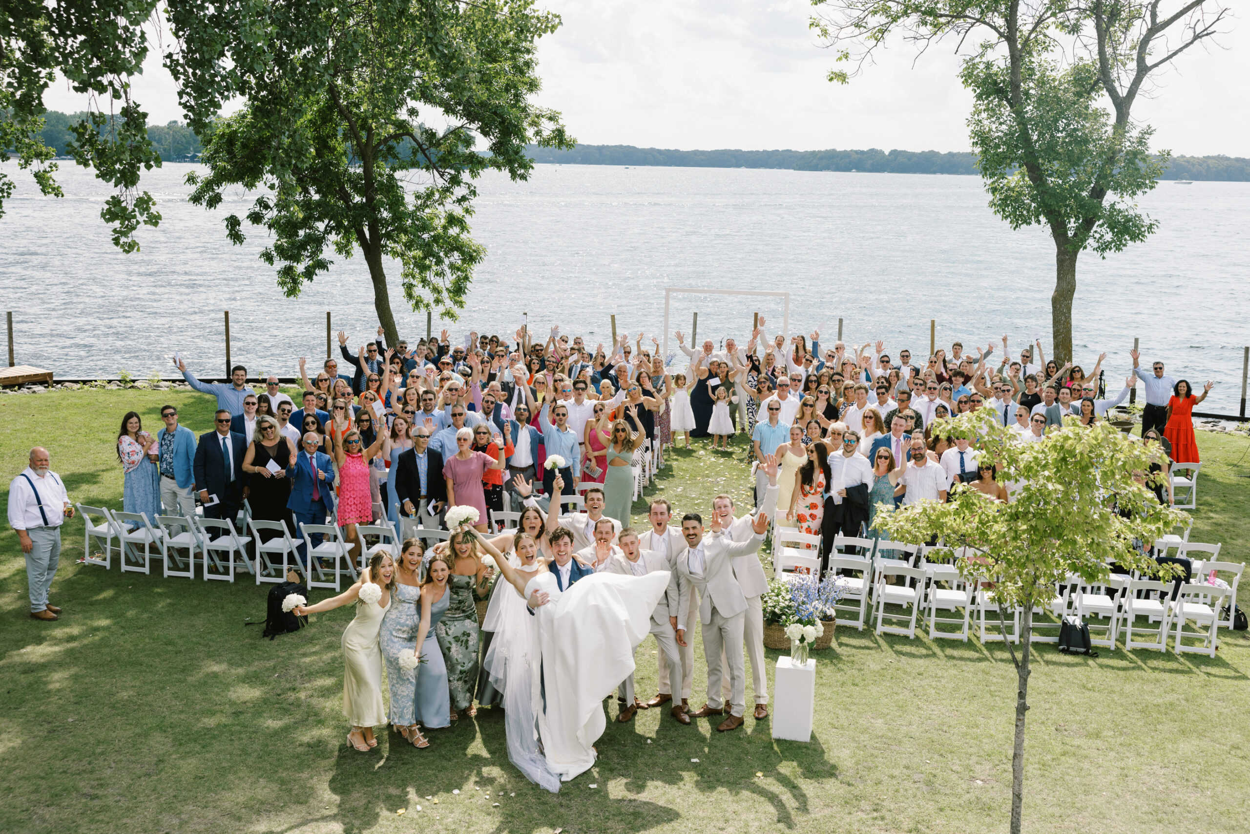 wedding party and guests smiling at ceremony at lake minnetonka yacht club
