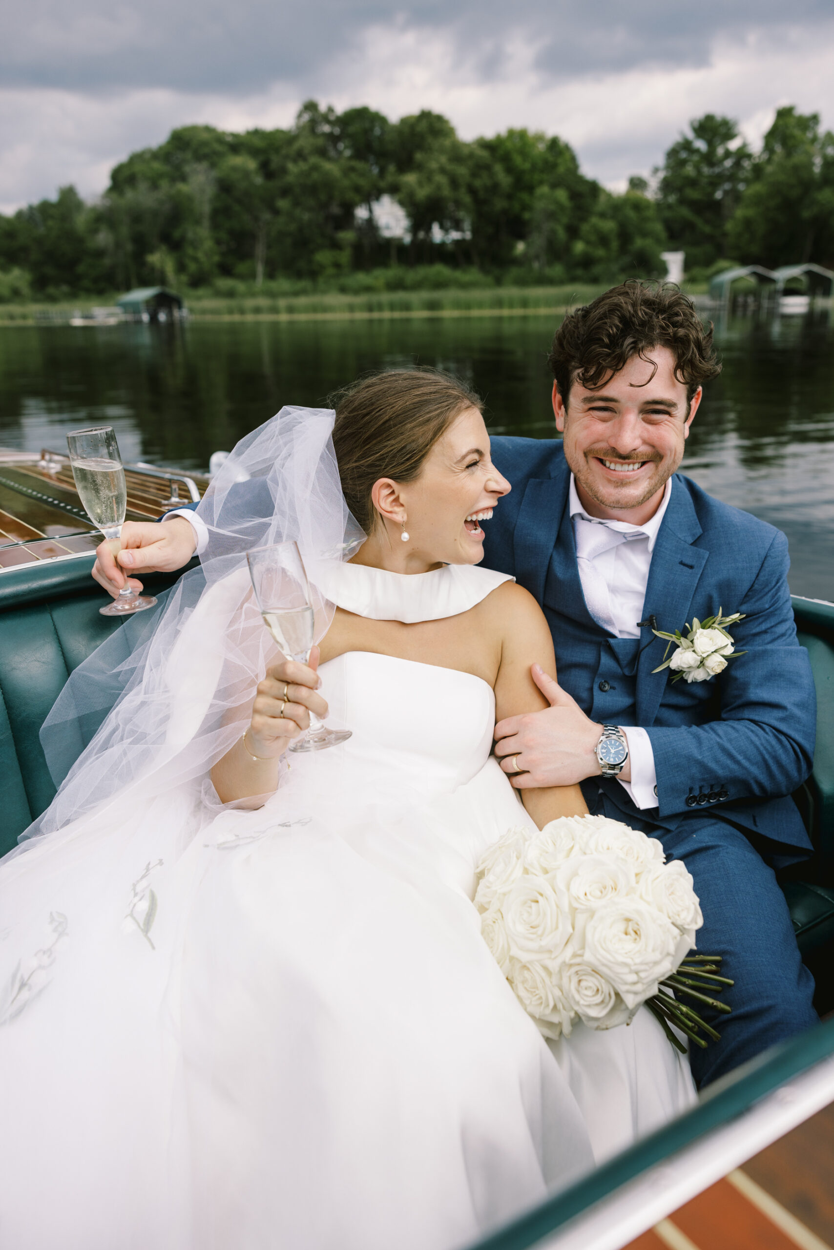 bride and groom laughing on boat at minnetonka yacht club wedding
