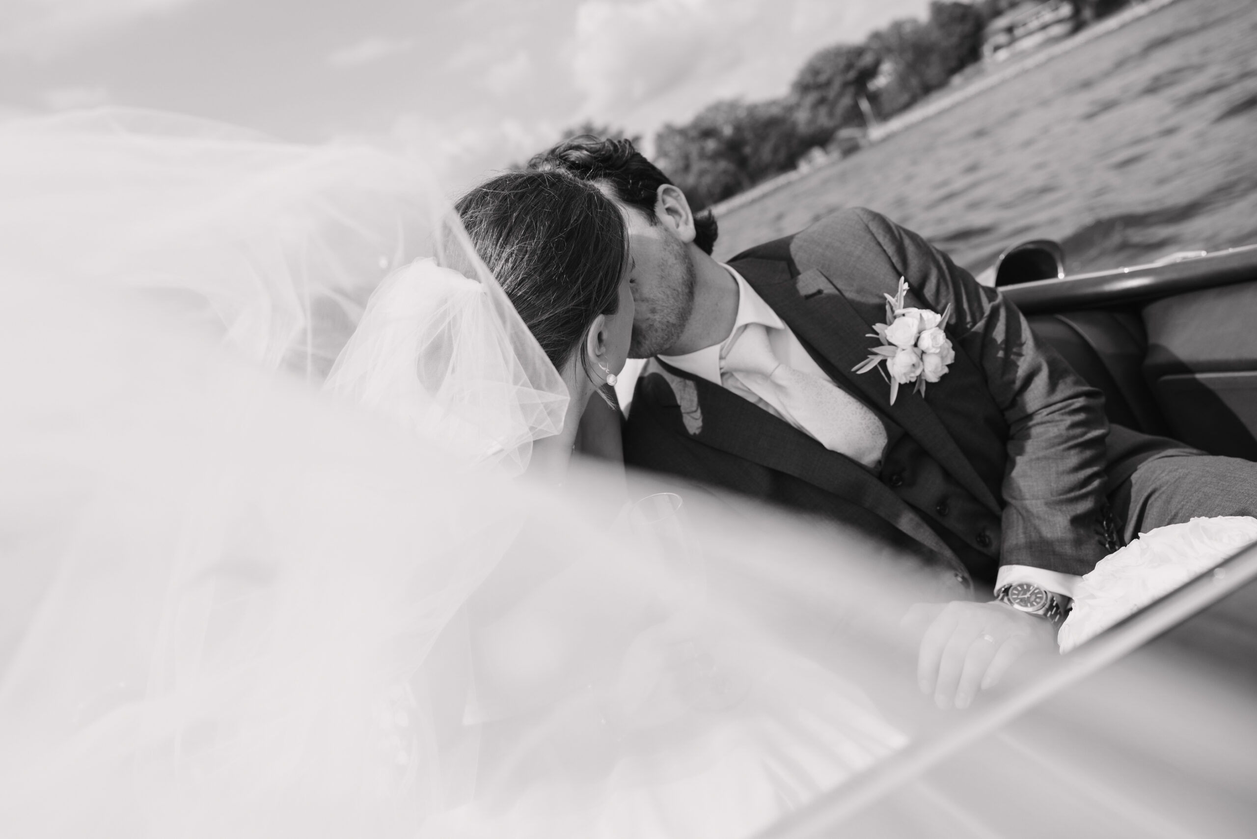 bride and groom kissing on boat at minnetonka yacht club wedding
