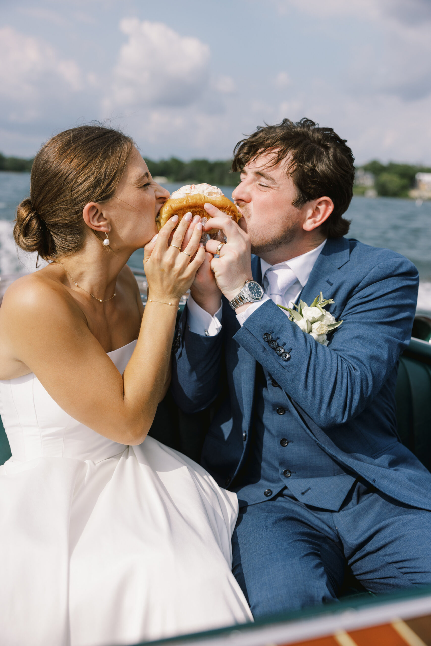bride and groom eating lobster roll at minnetonka yacht club wedding
