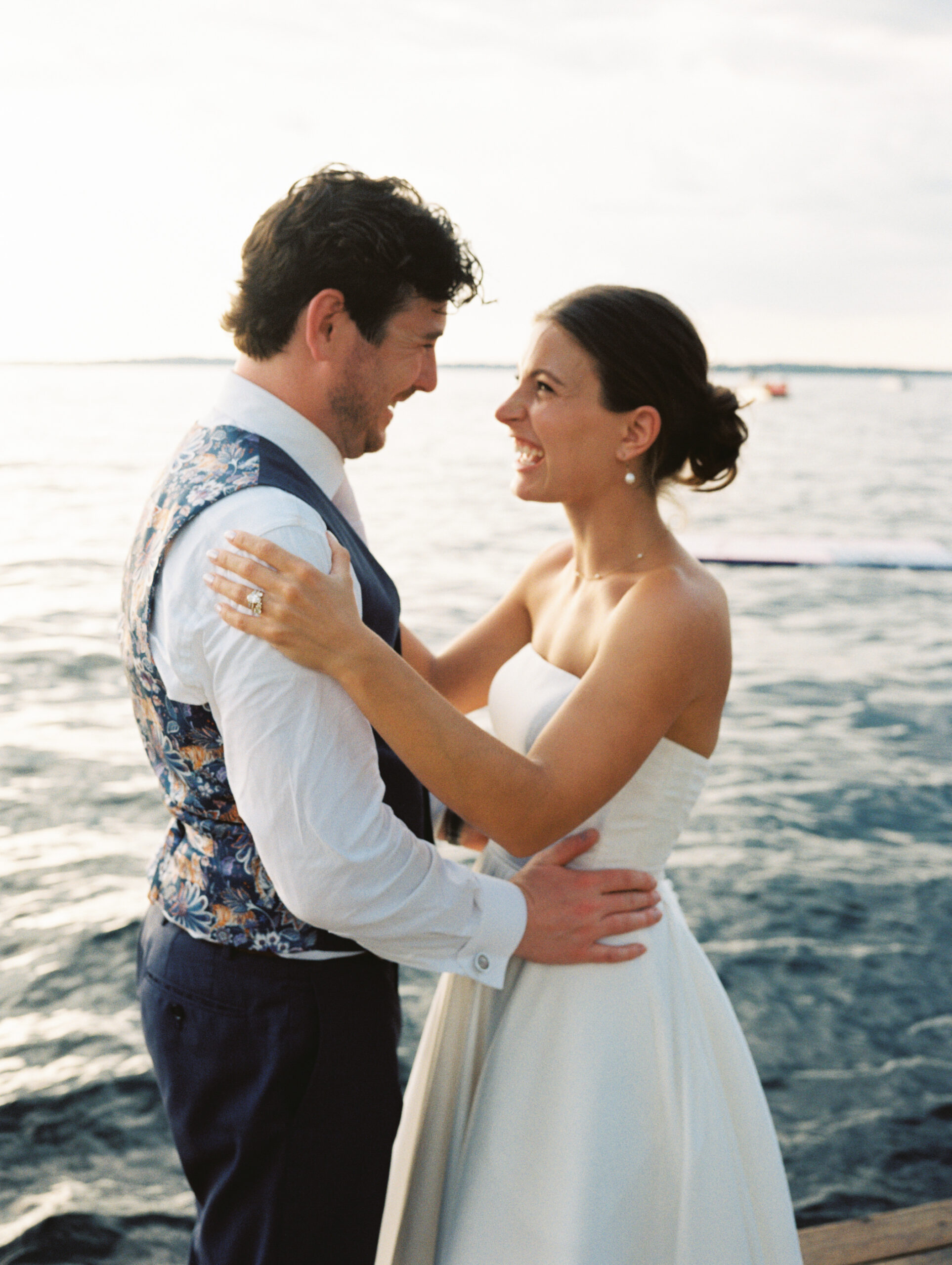 bride and groom embracing on dock at lake minnetonka yacht club
