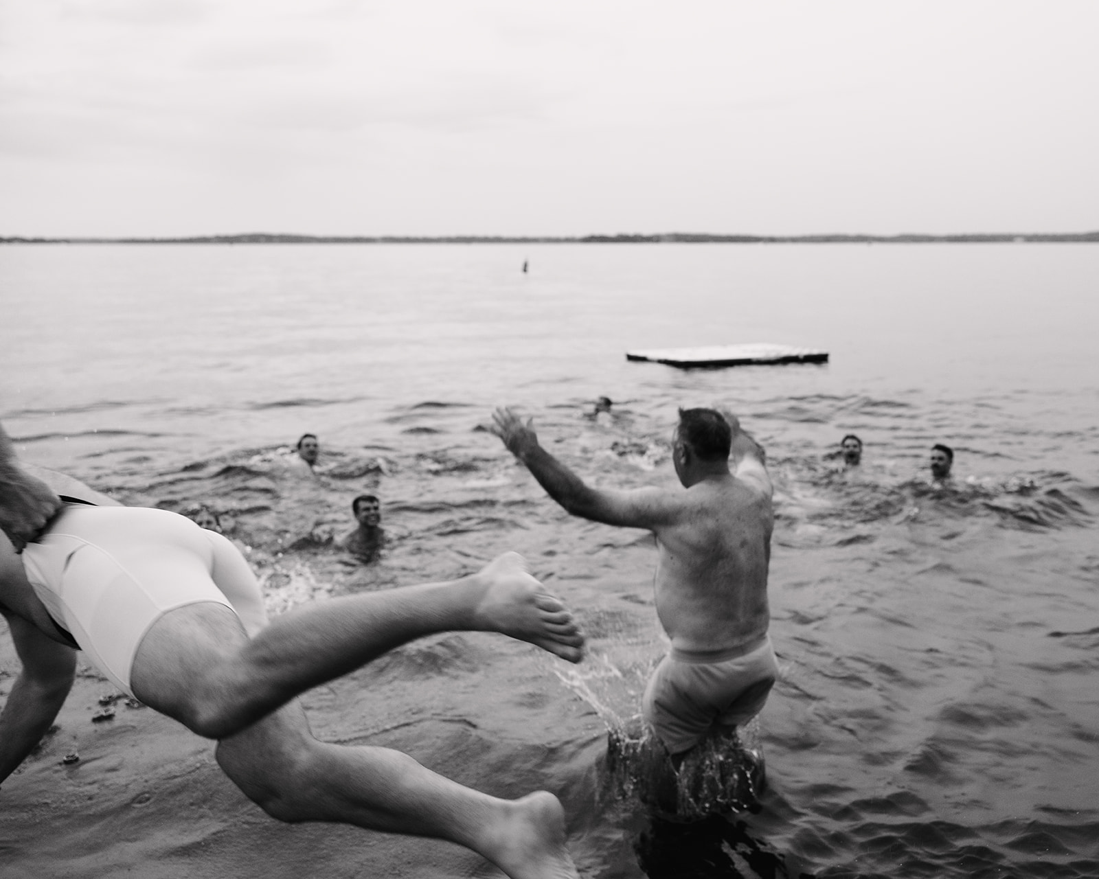 wedding guests jumping into lake at upper minnetonka yacht club
