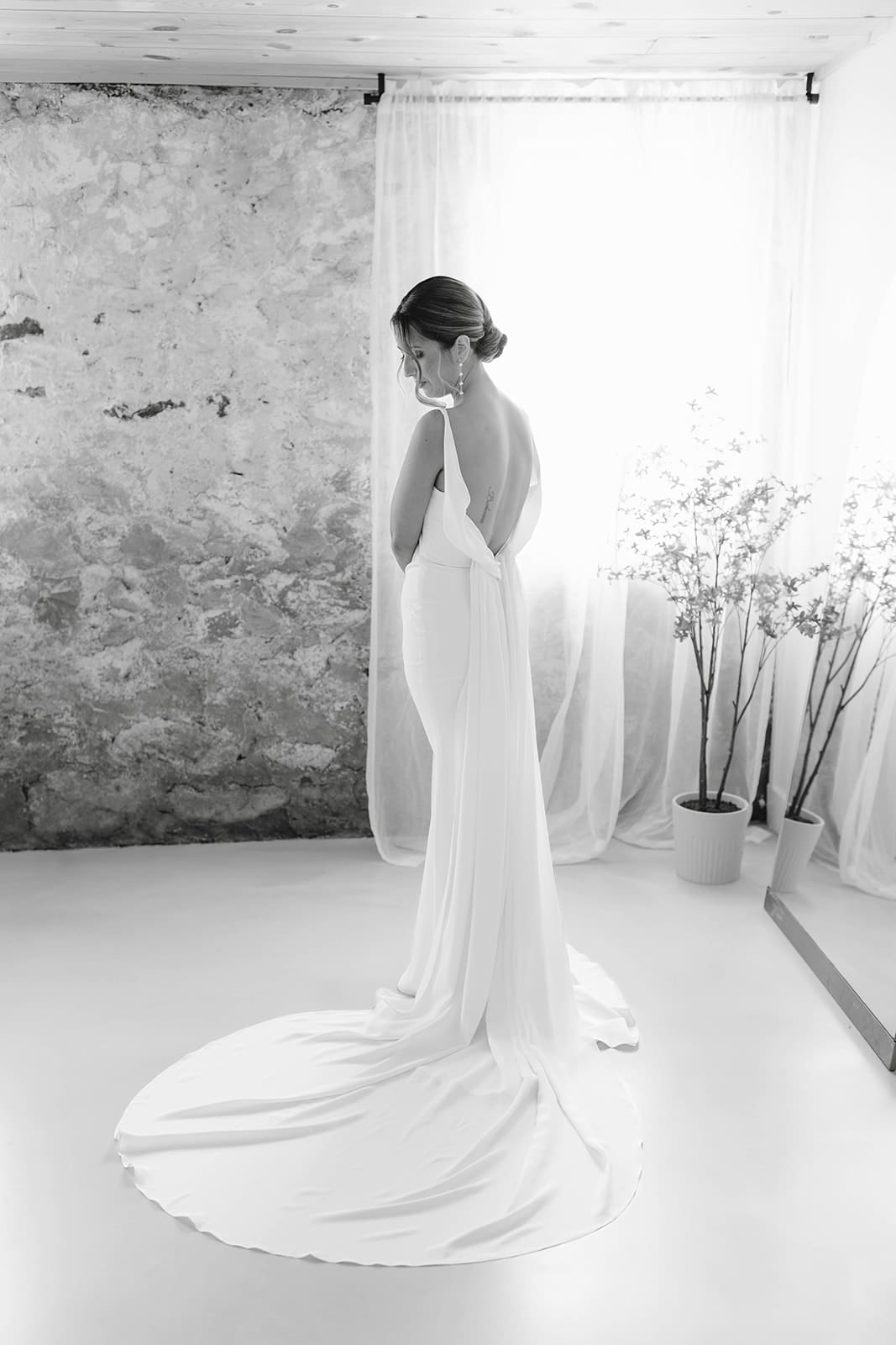 A bridal portrait of a bride looking over her shoulder after putting on the dress at an Ivory North wedding
