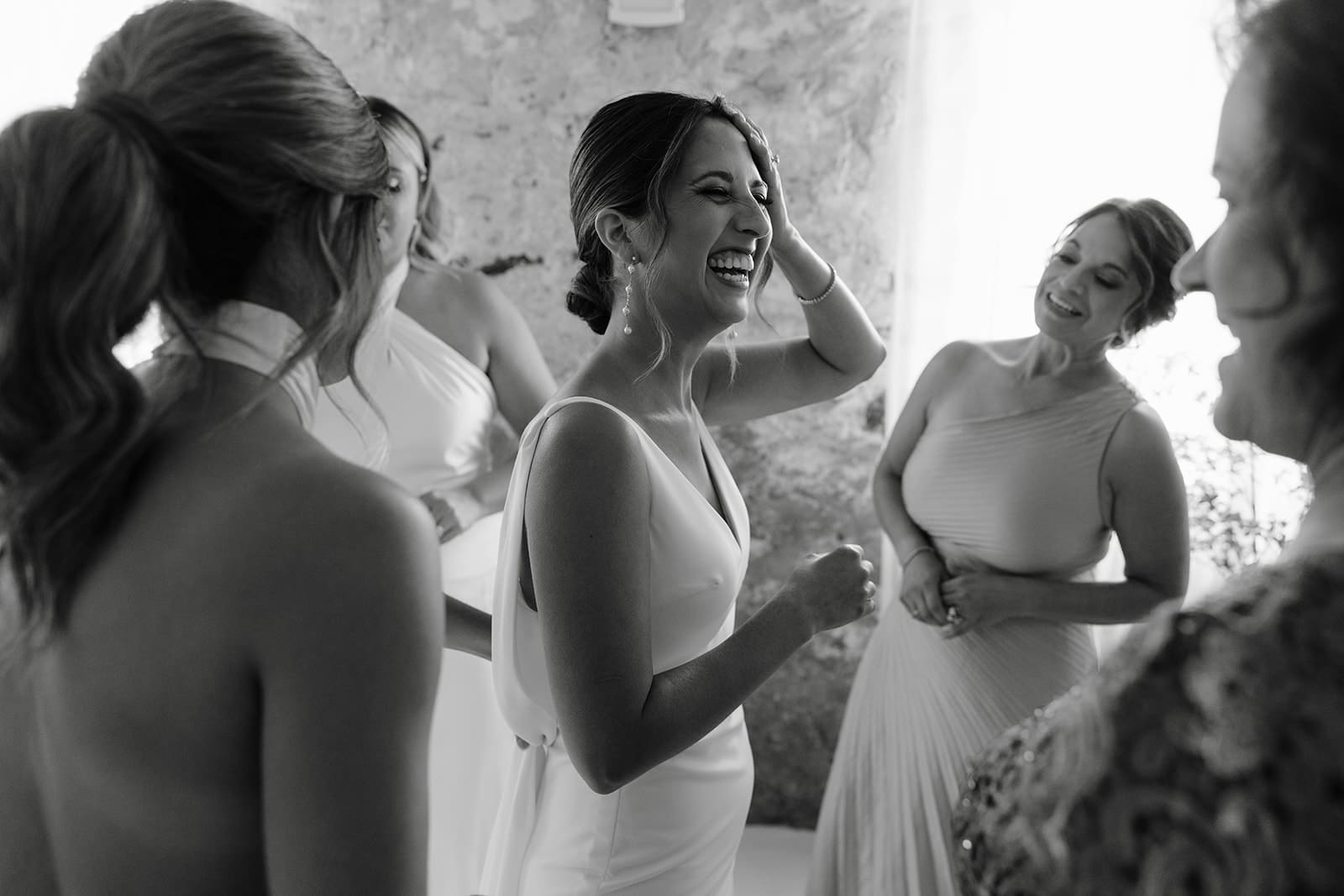 Bride laughing after getting ready with family and friends at ivory north wedding in Mora, MN. 