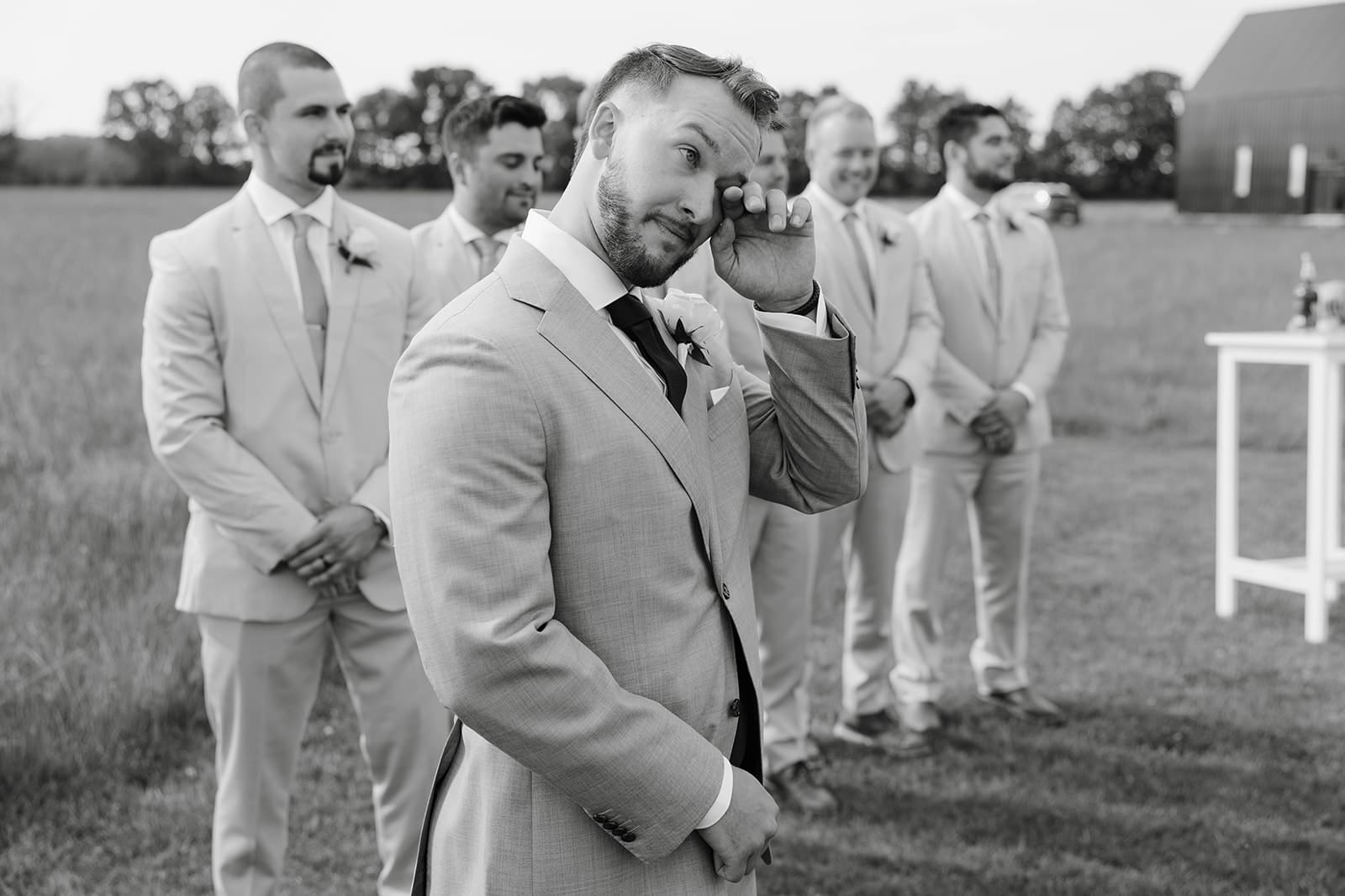 A candid photo of a groom crying at a summer wedding. Photo by Tom Thornton photography. 