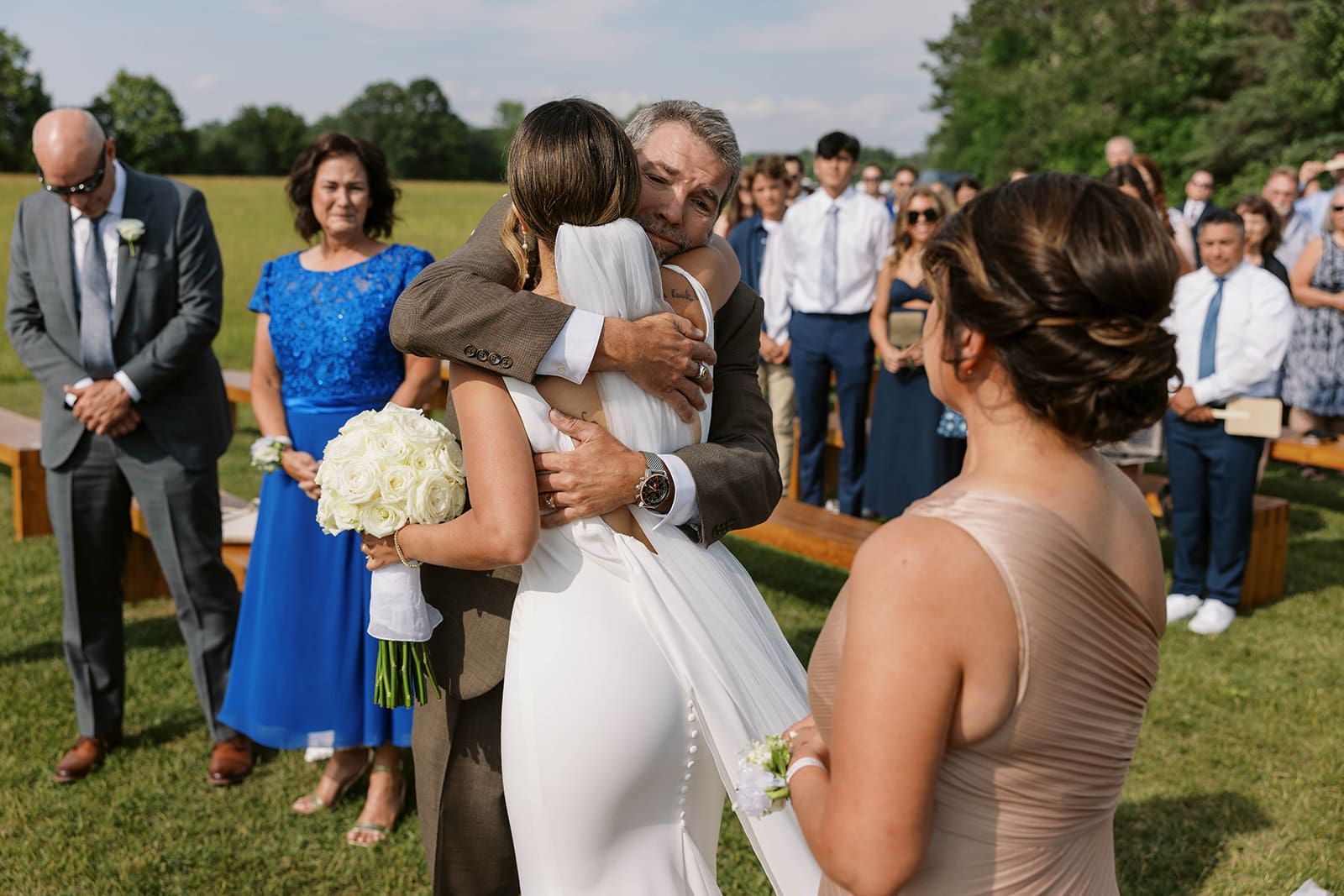 a Photo of a Bride hugging her parents after walking down the aisle at an Ivory North wedding ceremony. 