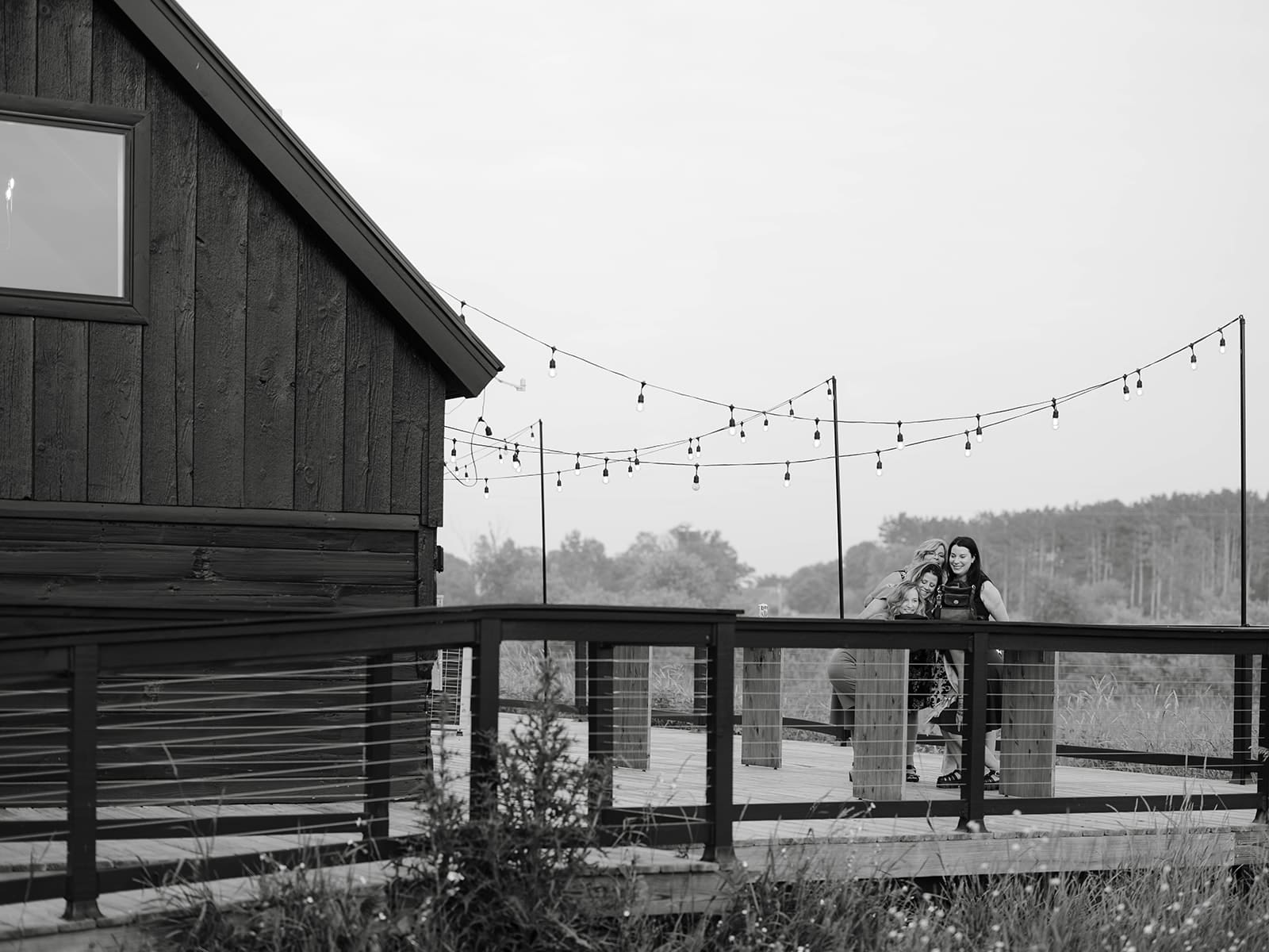 Wedding guests posing for a photo on a deck during a reception at ivory north wedding. 