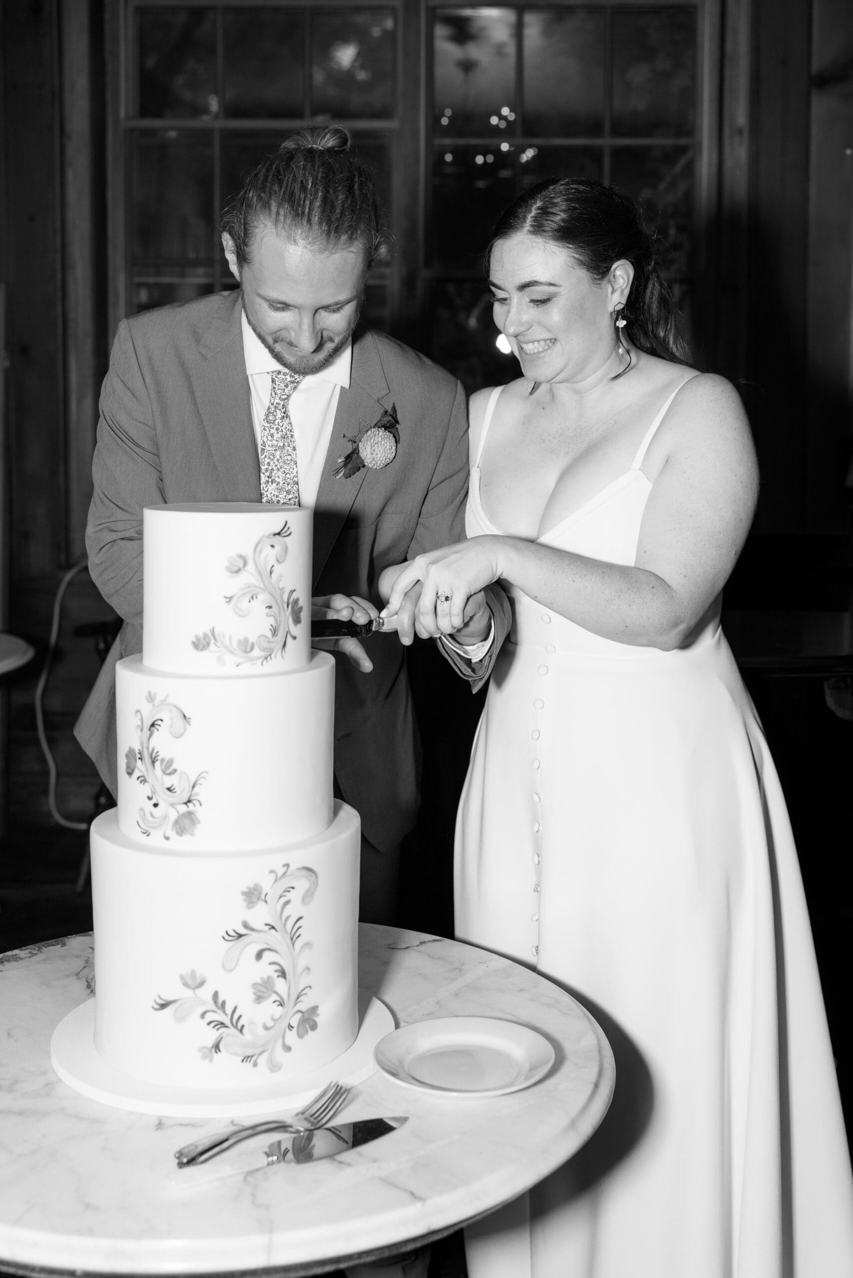 Bride and Groom cutting their cake from Ink Sweets for their wedding reception at the outing lodge.