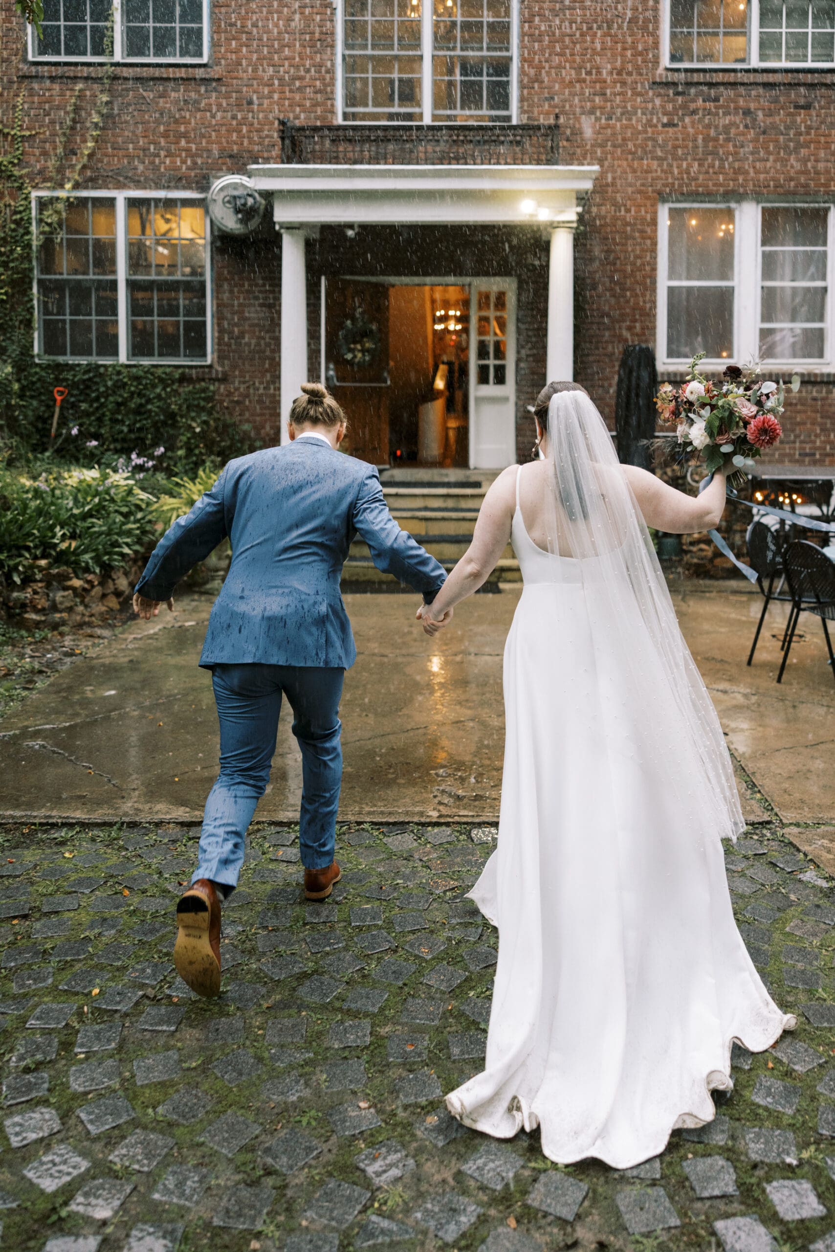 Bride and Groom running through the rain after their wedding ceremony at the Outing lodge in stillwater, MN. 