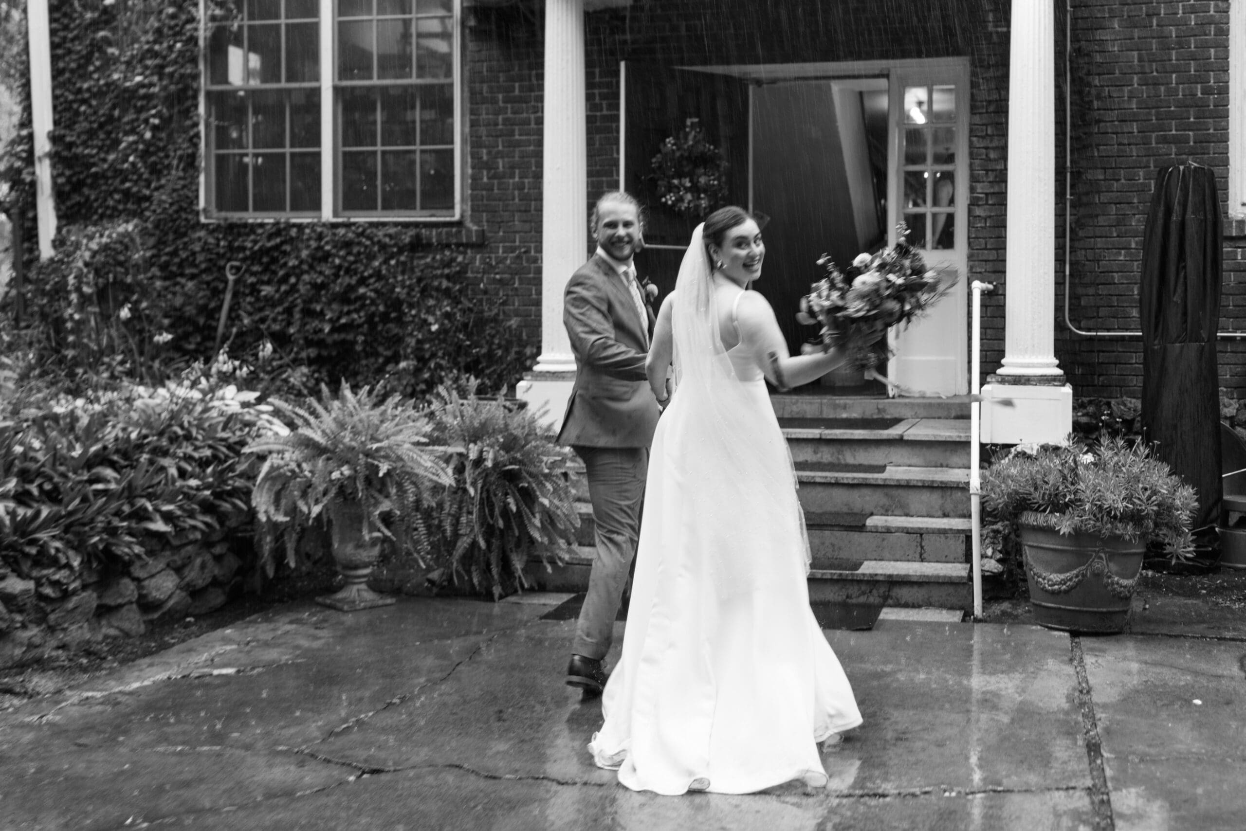 Bride and Groom running through the rain after their wedding ceremony at the Outing lodge in stillwater, MN. 