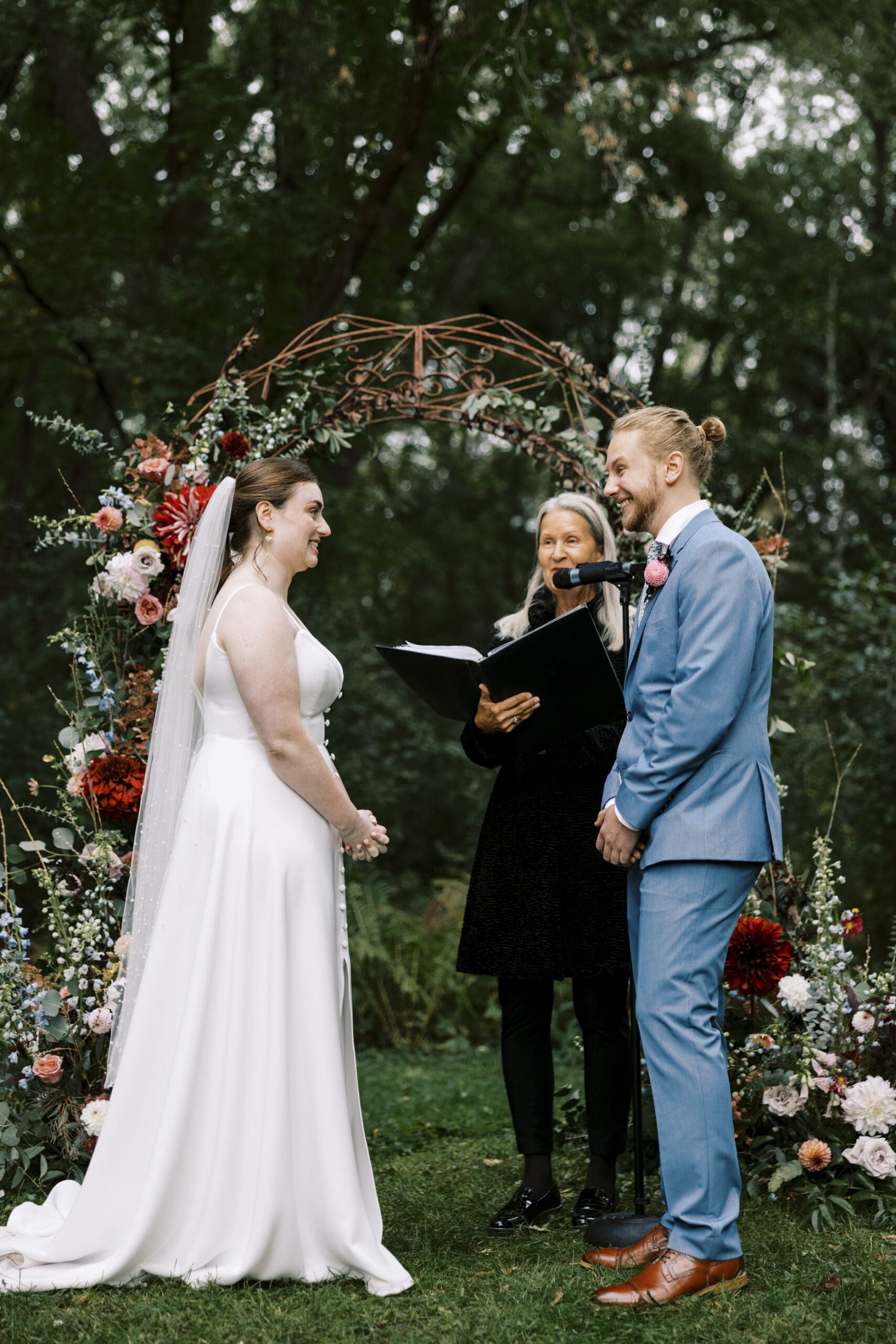 Bride and groom during the rainy garden wedding ceremony at The Outing lodge in Stillwater, Minnesota.