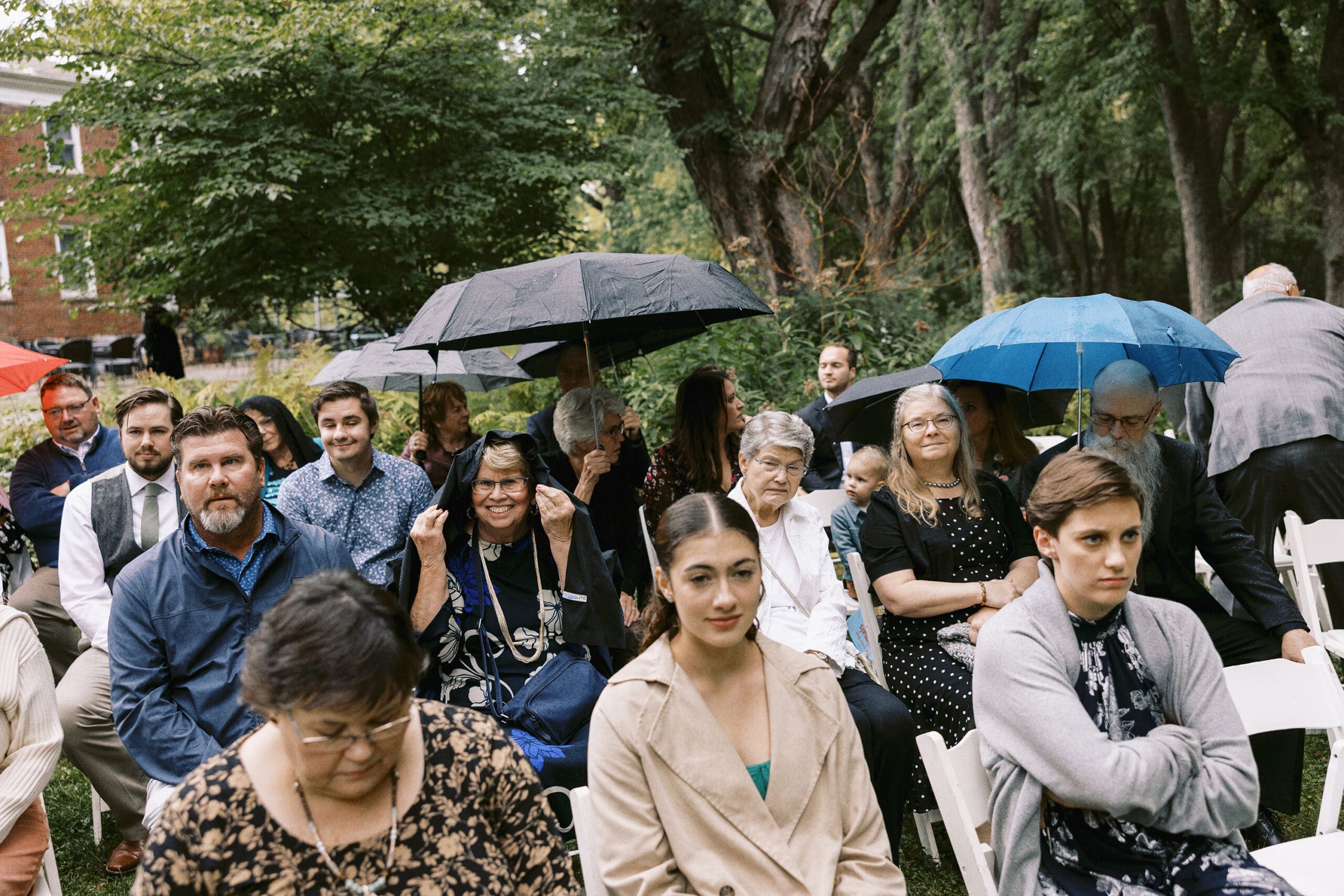 Guests sitting and waiting in the rain for the wedding ceremony at The Outing Lodge. 