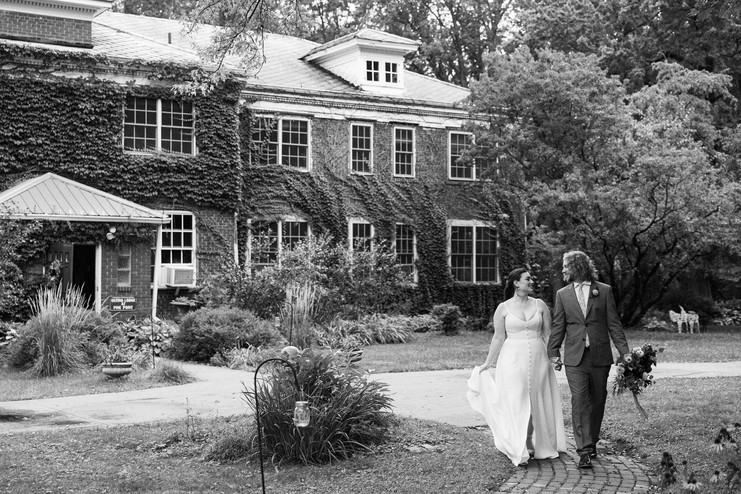 Bridal wedding portraits walking together outside on the front lawn of the Outing Lodge in Stillwater, MN. 