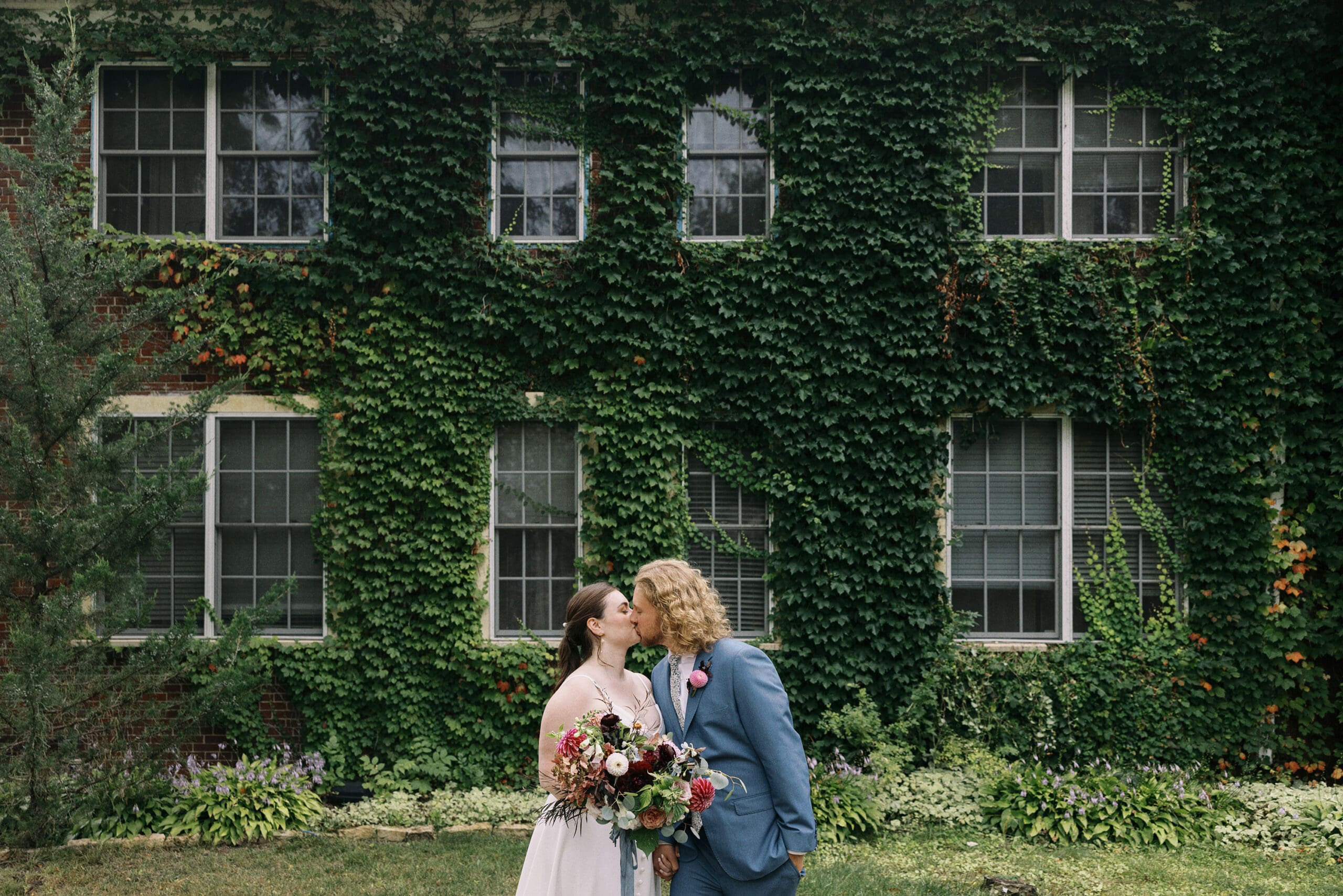 Bride and Groom kissing portraits outside the ivy wall at the Outing Lodge in Stillwater, MN.